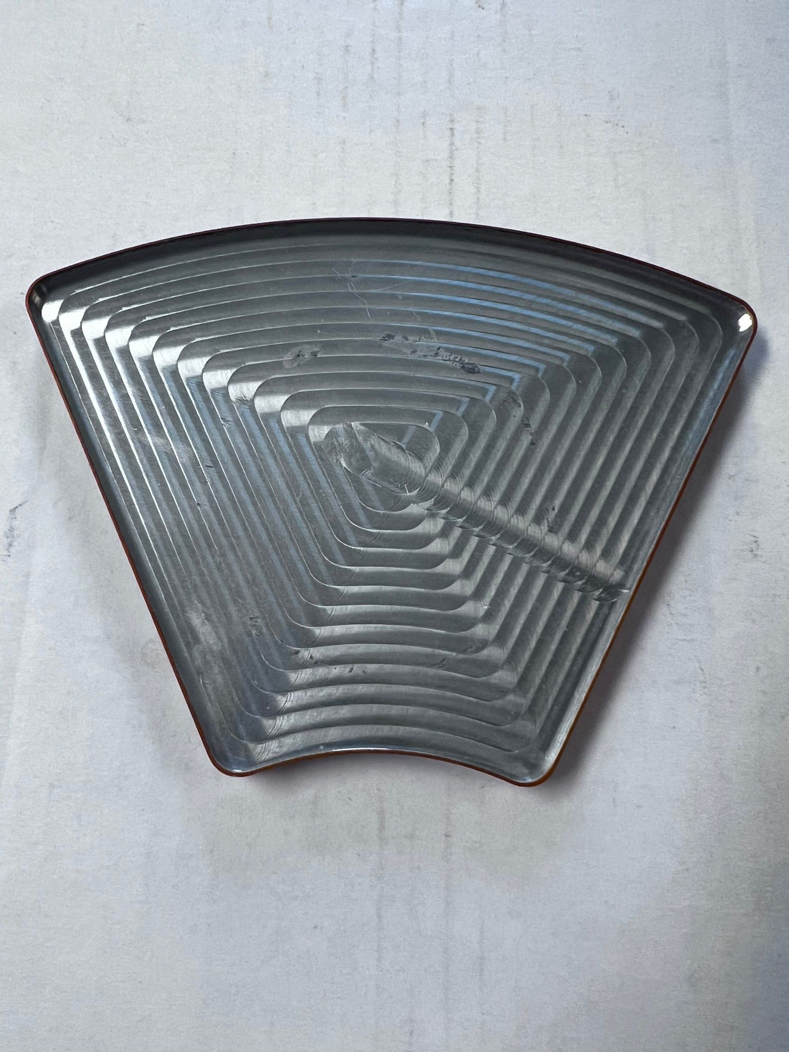 A metal tray with a spider web design on it