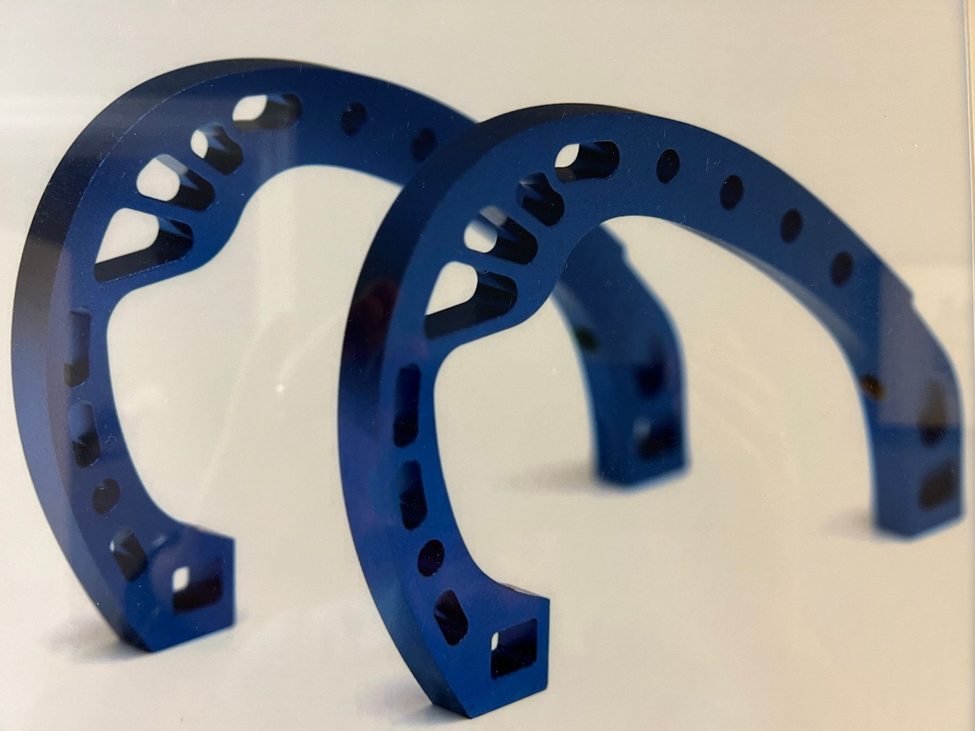 A pair of blue horseshoes on a white surface