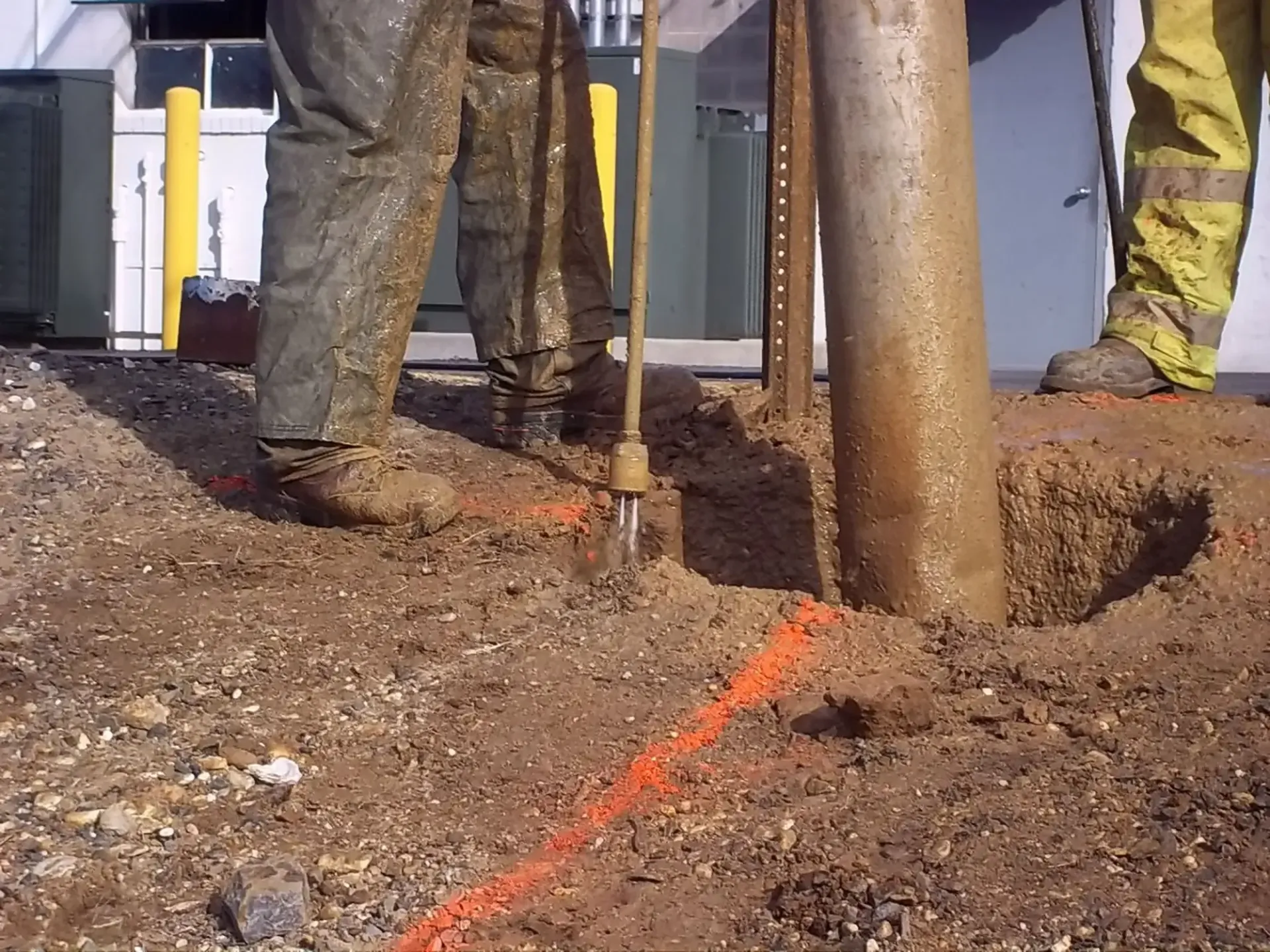 Worker guiding daylighting process around shallow irrigation line