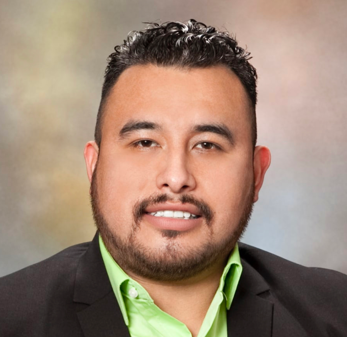 a man with a beard is wearing a blue shirt .