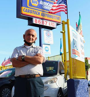 A person nex to the service sign | Carotech Automotive