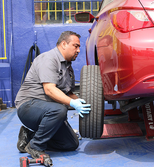Mechanic changing a tire | Carotech Automotive