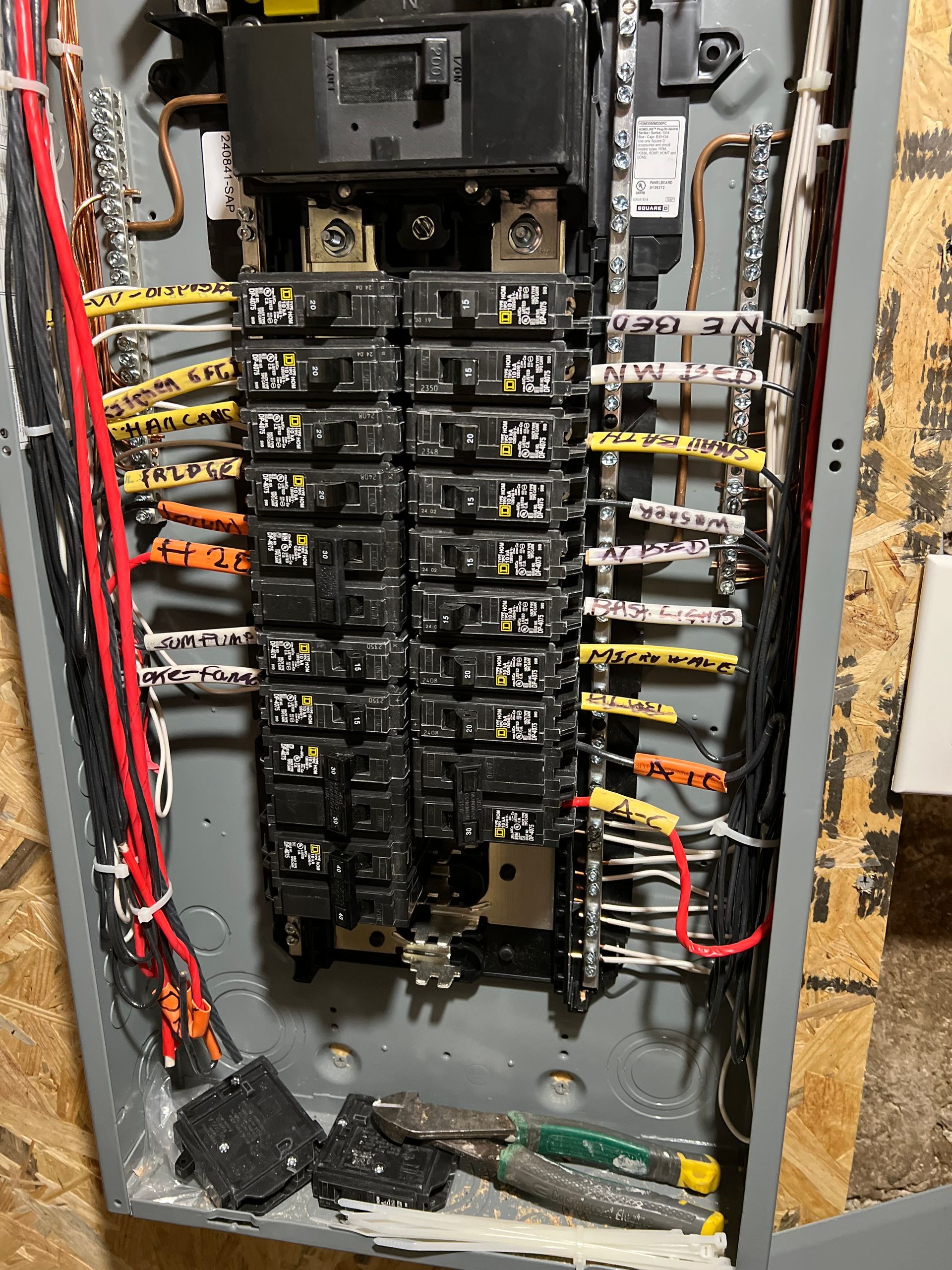 A dirty electrical panel with a lot of wires coming out of it.