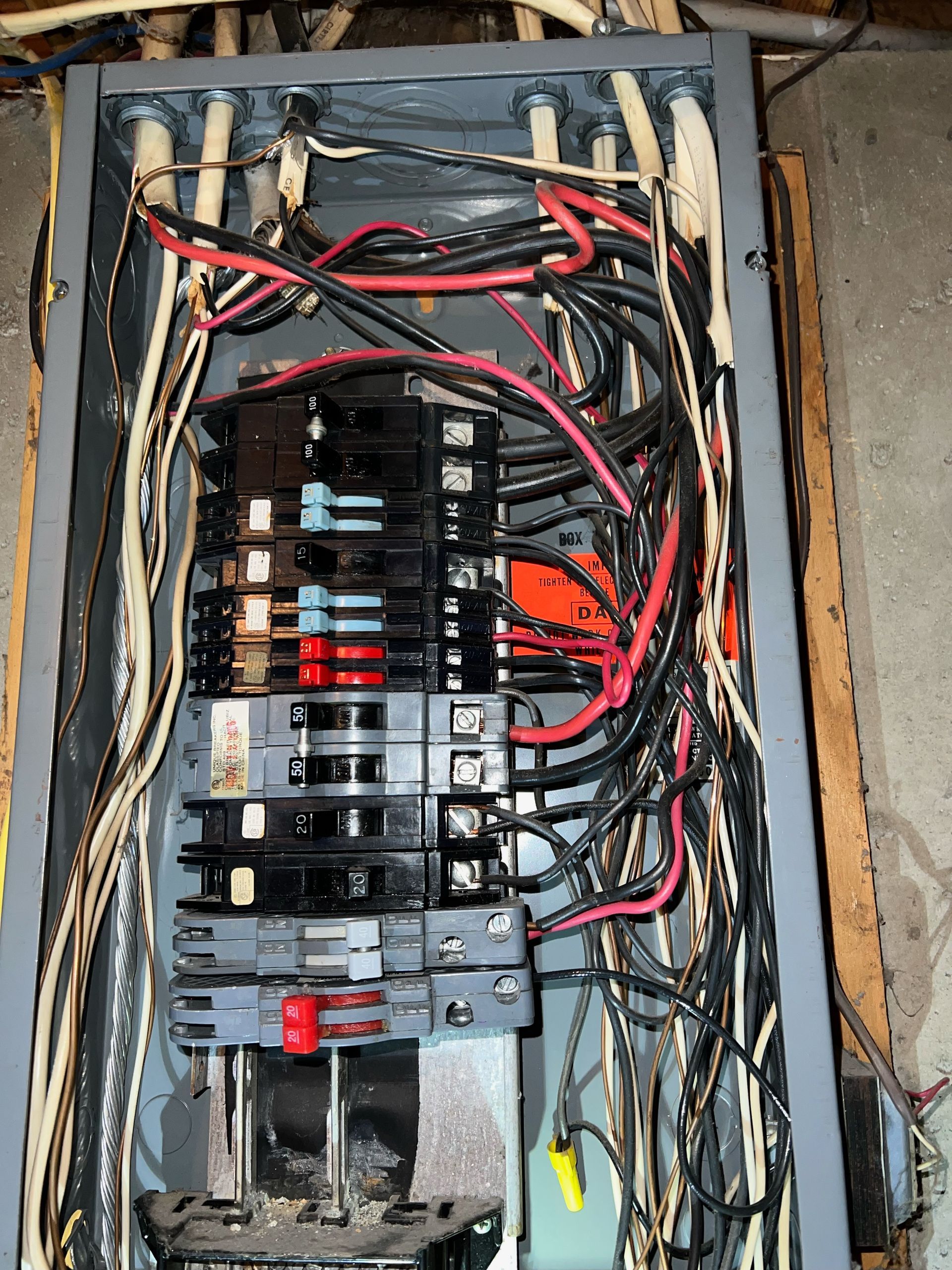 A very messy electrical box with many wires coming out of it
