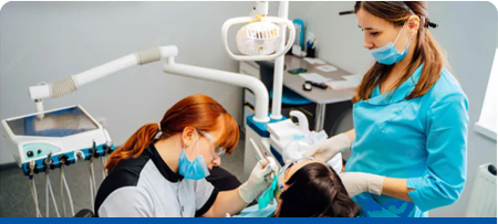 A dentist is examining a patient 's teeth in a dental office.