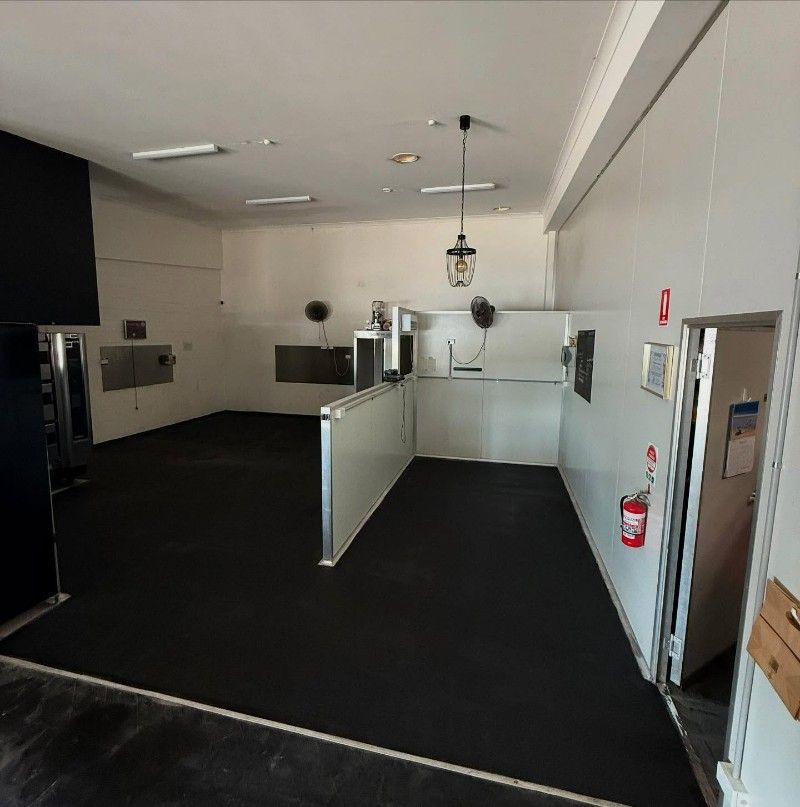 An Empty Room With a Fire Extinguisher on the Wall — Premier Epoxy Flooring Wollongong in Fairy Meadow, NSW