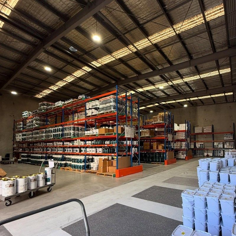 A warehouse with shelves of epoxy — Premier Epoxy Flooring Wollongong in Wollongong, NSW