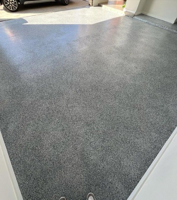 A Car is Parked in a Garage With a Gray Floor — Premier Epoxy Flooring Wollongong In Wollongong, NSW