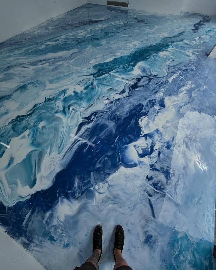 A Person is Standing on a Blue and White Marble Floor — Premier Epoxy Flooring Wollongong In Wollongong, NSW