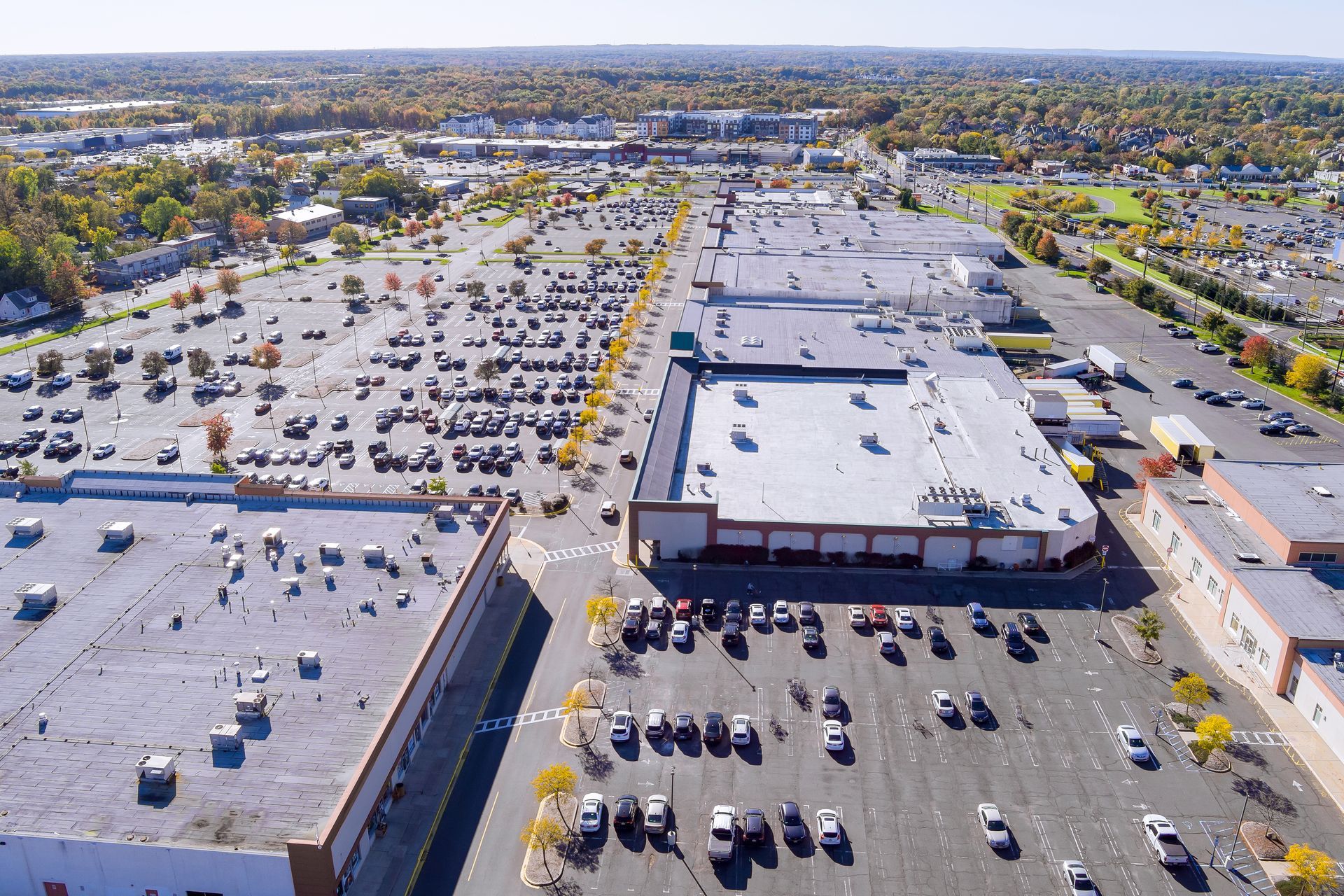 Aerial view of a large shopping center with numerous cars in the parking lot.