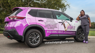 Woman leans on a purple and white car with business logo. Woman leans on a purple and white car with business logo.
