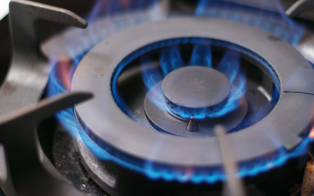 Close-up of a blue gas flame burning from a stove burner.