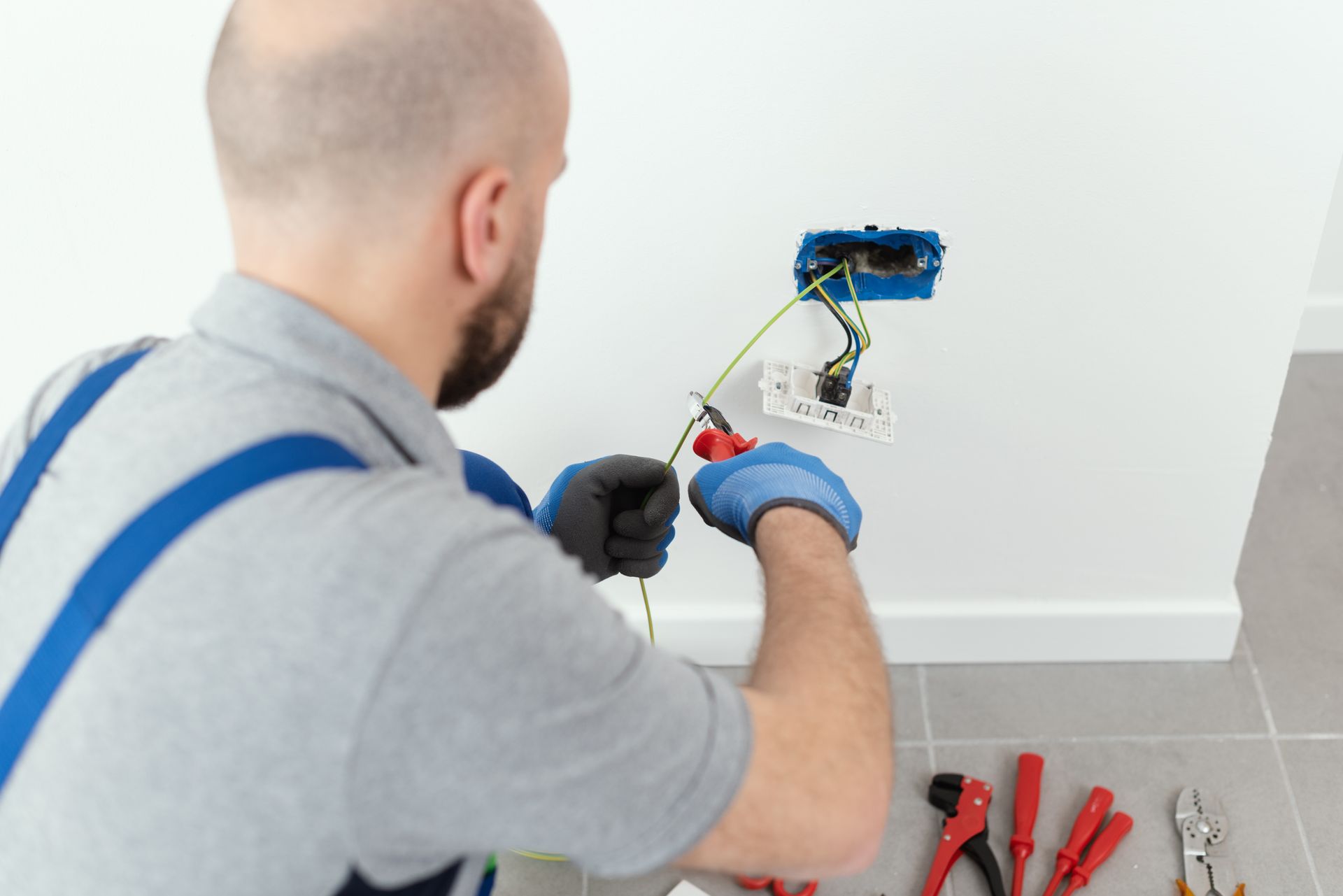 Professional electrician installing a wall socket, providing high-quality electrician services.