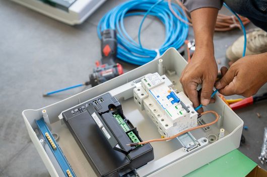 Technician connecting wires for an electrical power system at a local electrical repair shop.
