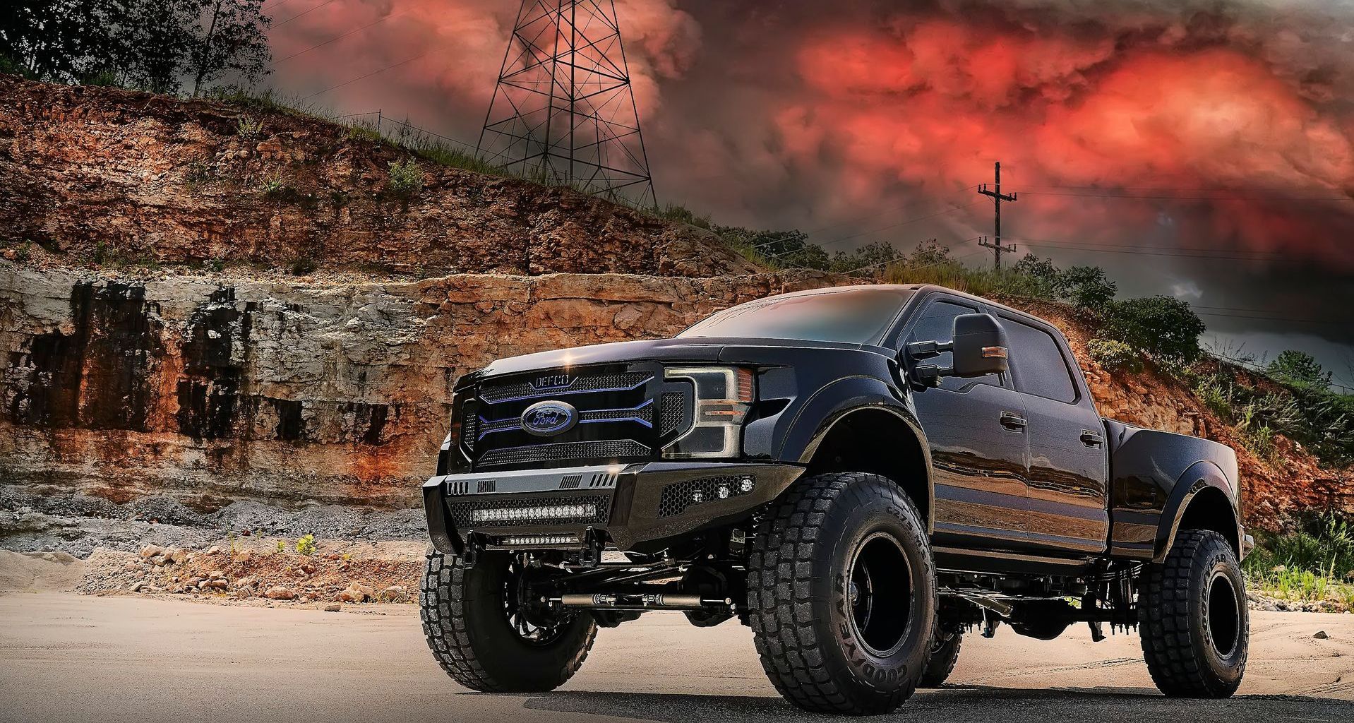 A black ford truck is parked on the side of the road.