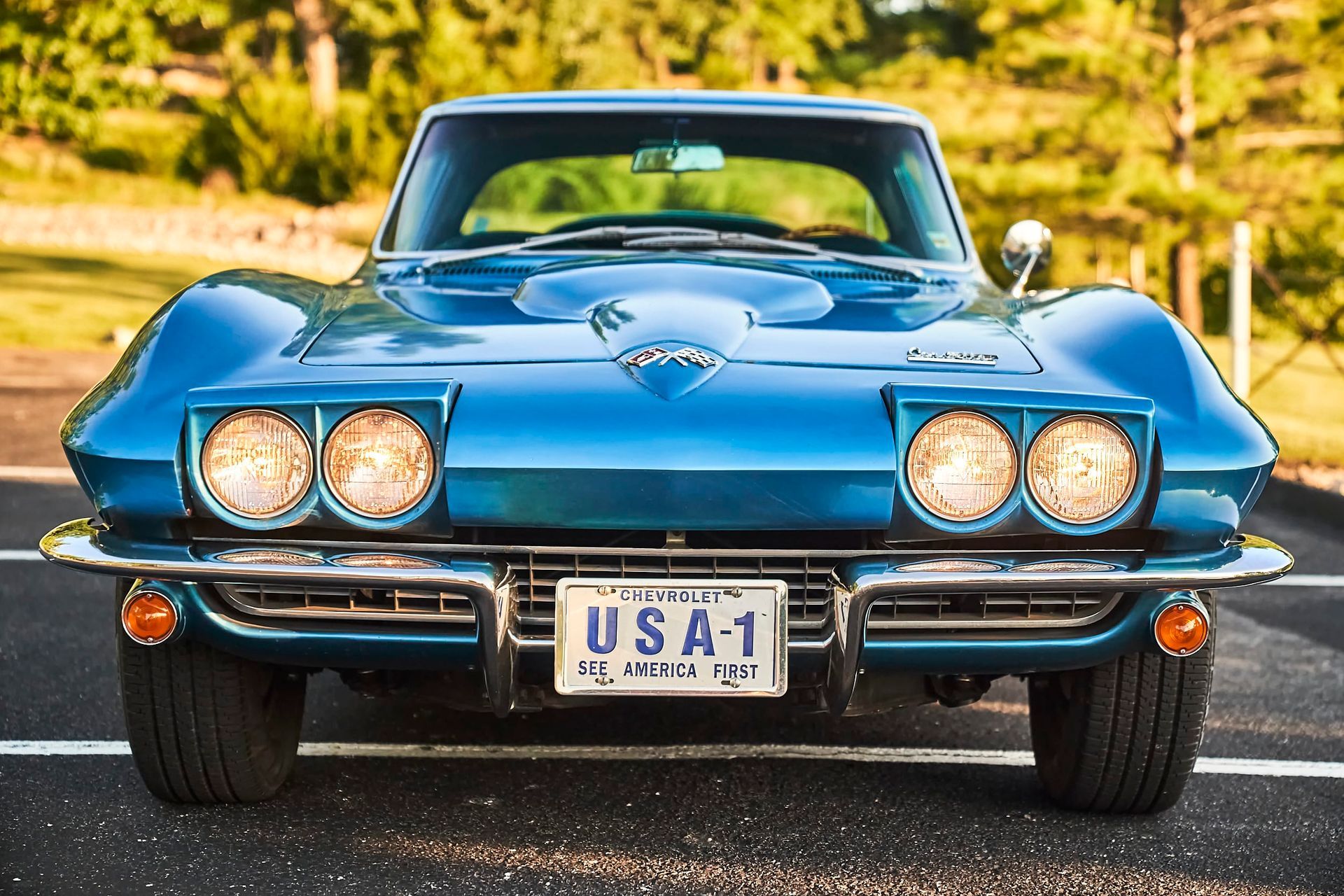 A classic blue Corvette Sting Ray with pop-up headlights and the license plate