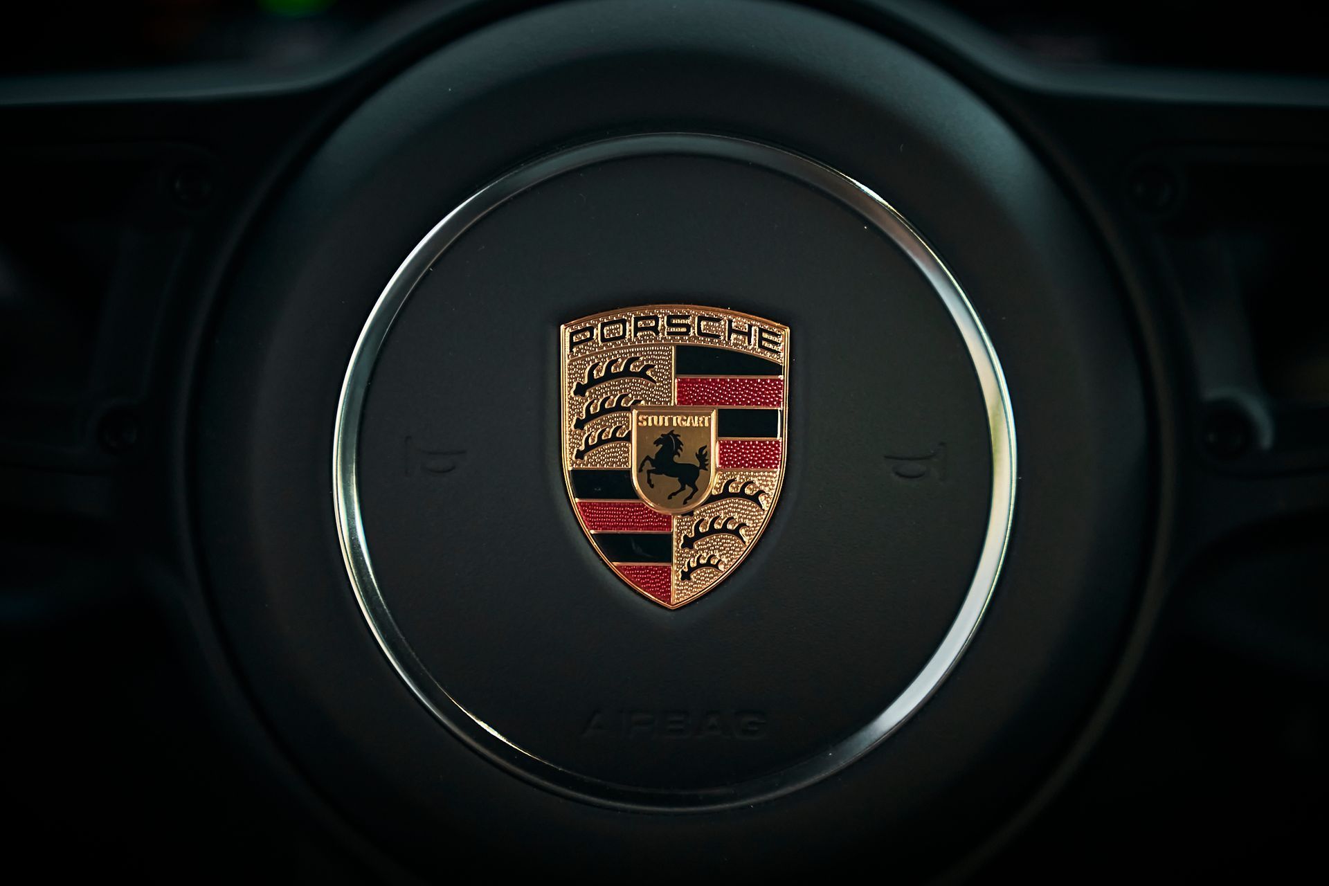A close up of a porsche steering wheel