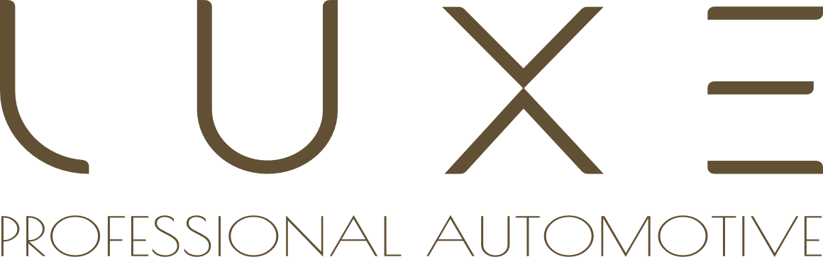 A logo for luxe professional automotive with a mountain in the background.