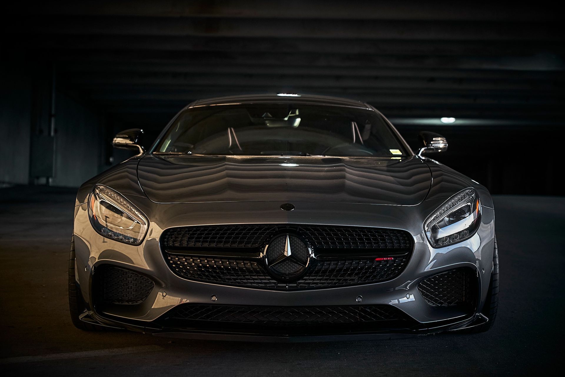 A mercedes benz gt is parked in a dark parking garage.