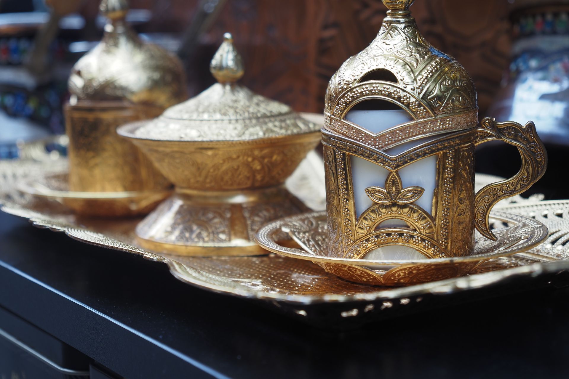 A cup of coffee is sitting on a saucer on a tray.