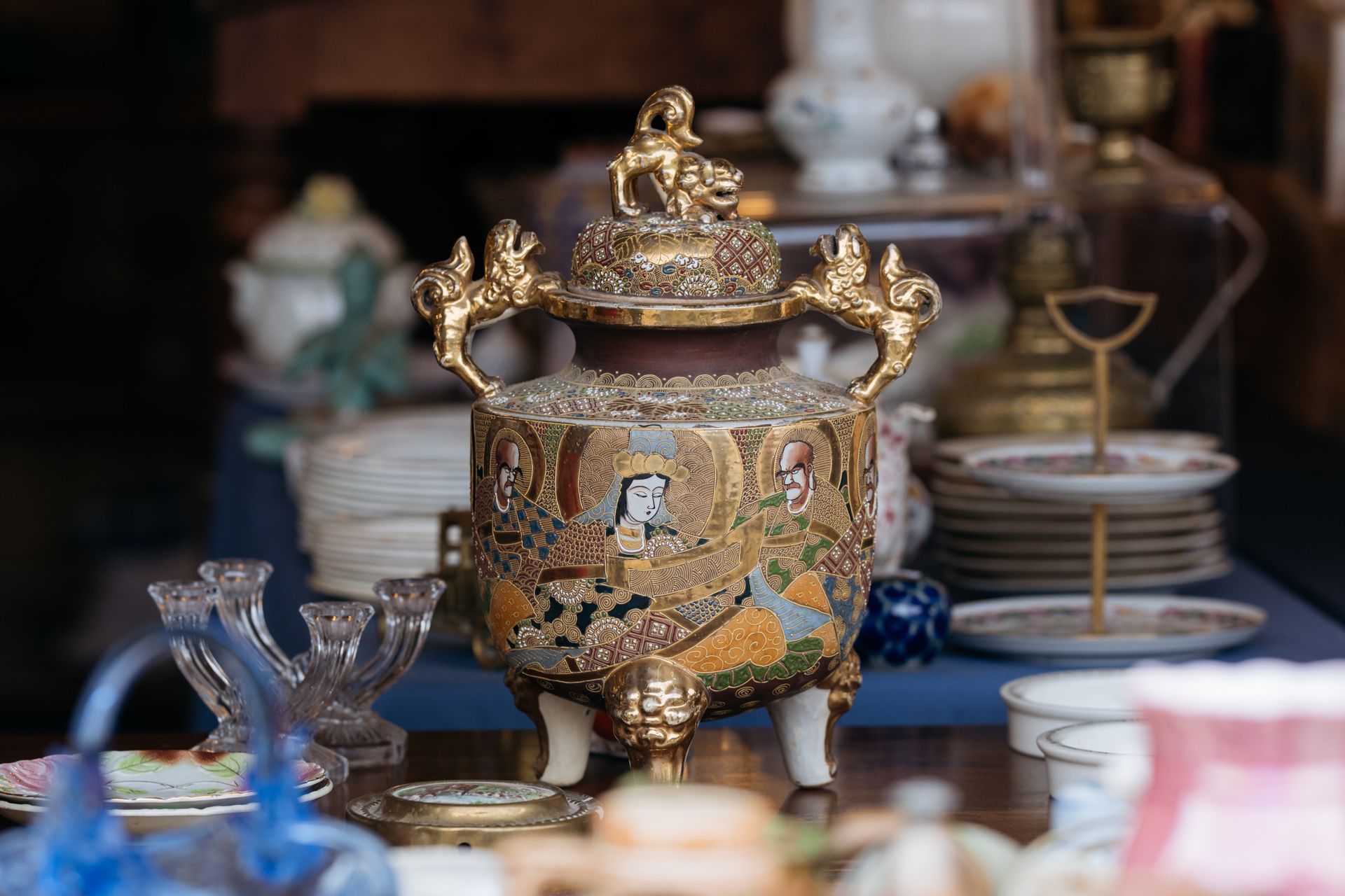 A vase with a lid is sitting on top of a table.