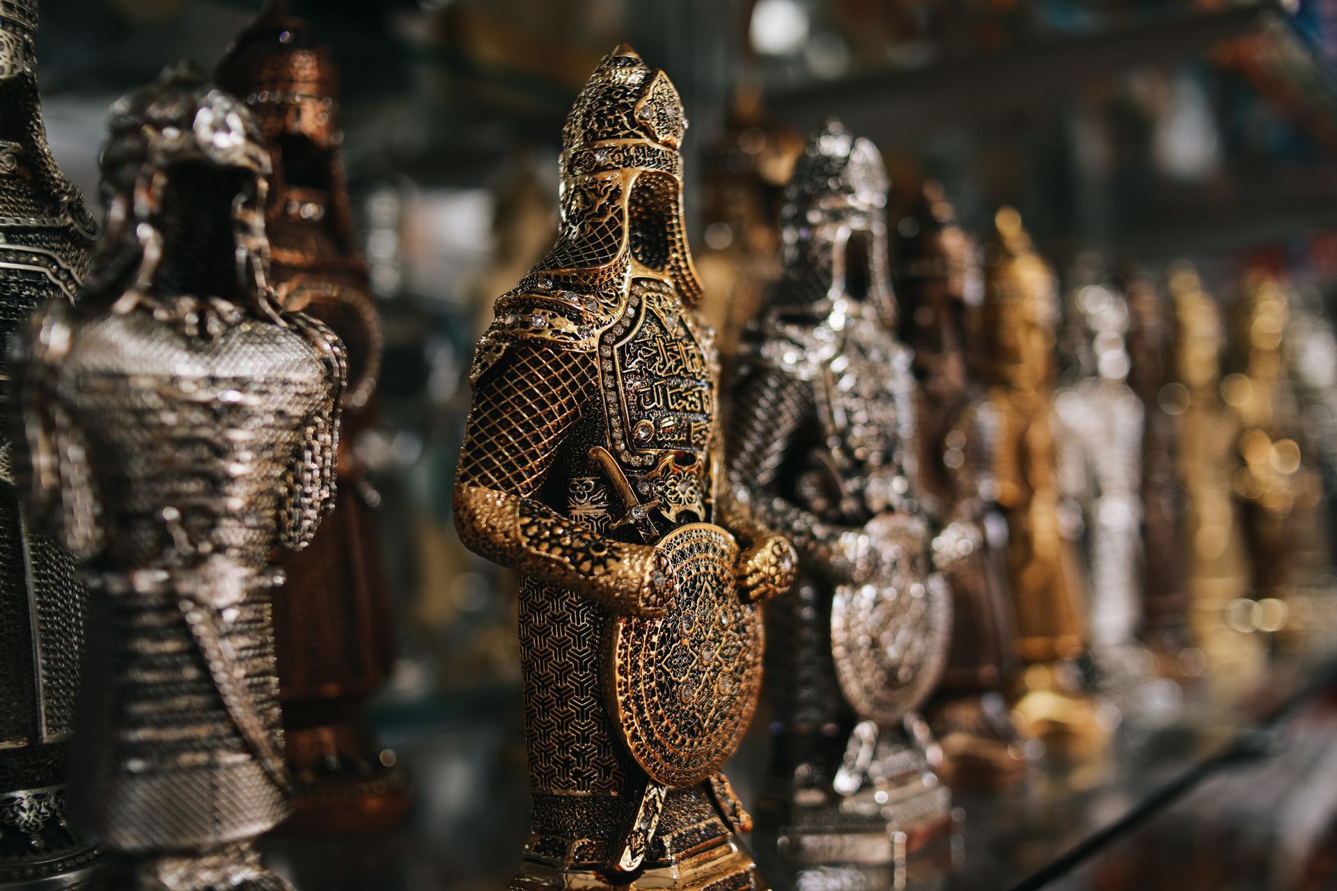 A row of chess pieces sitting on top of a glass shelf.