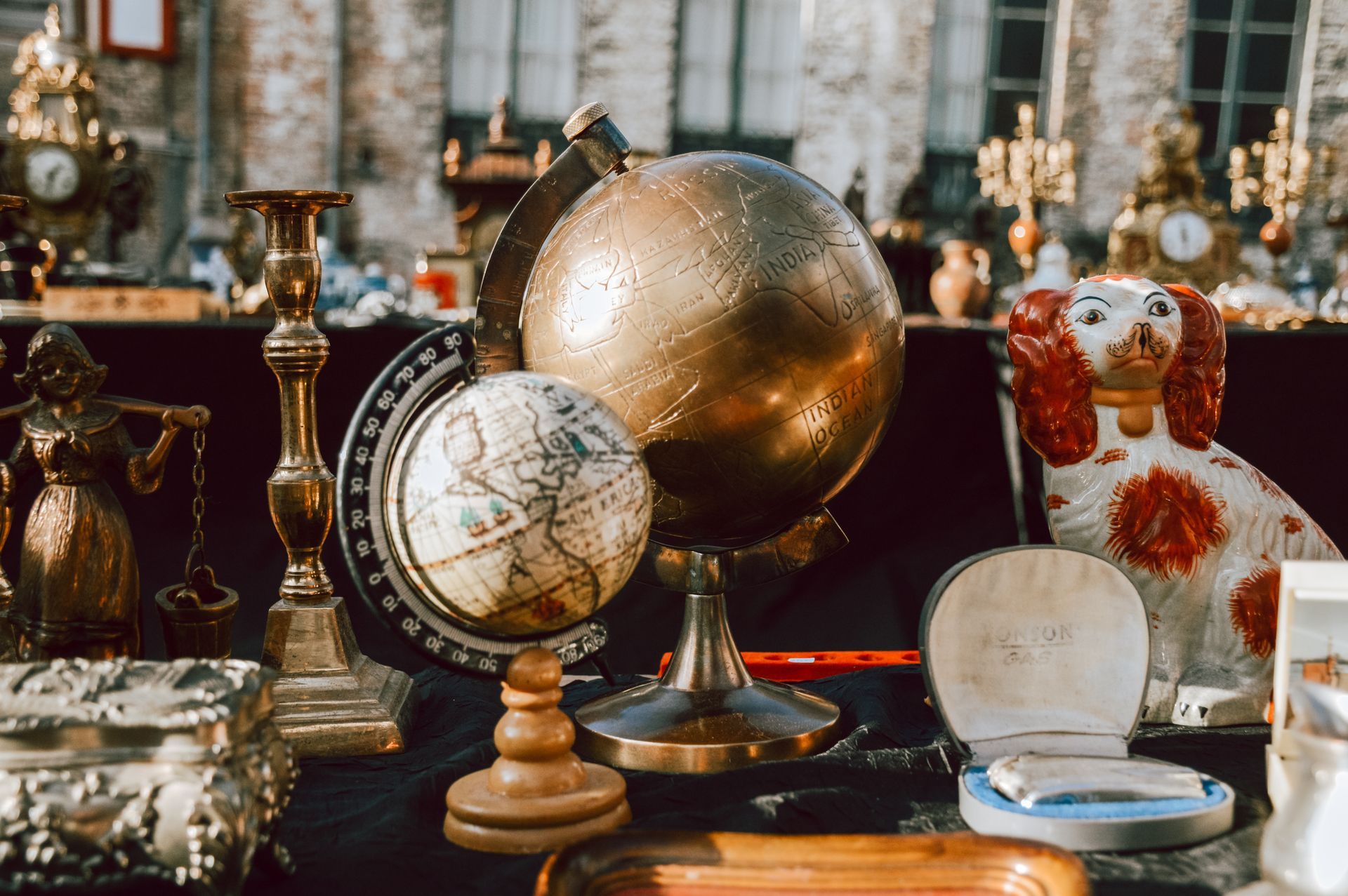 A globe is sitting on top of a table next to a statue of a dog.