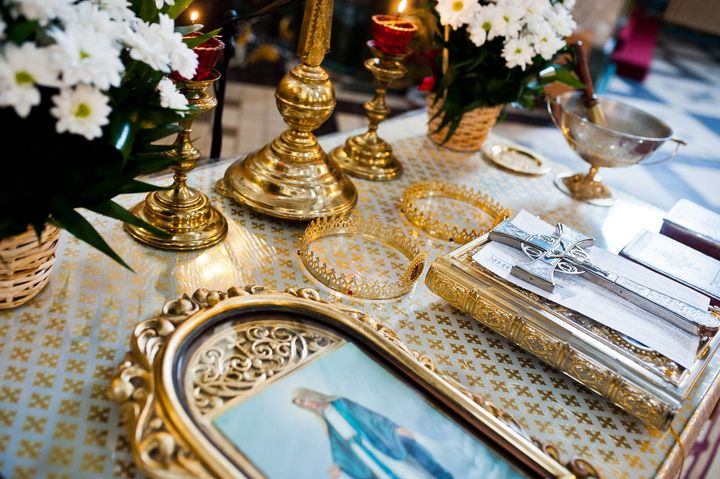 A picture of a woman in a blue dress is on a table with candles and flowers.