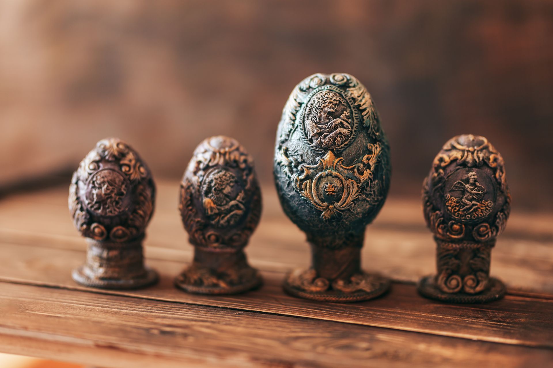 Four easter eggs are sitting on a wooden table.