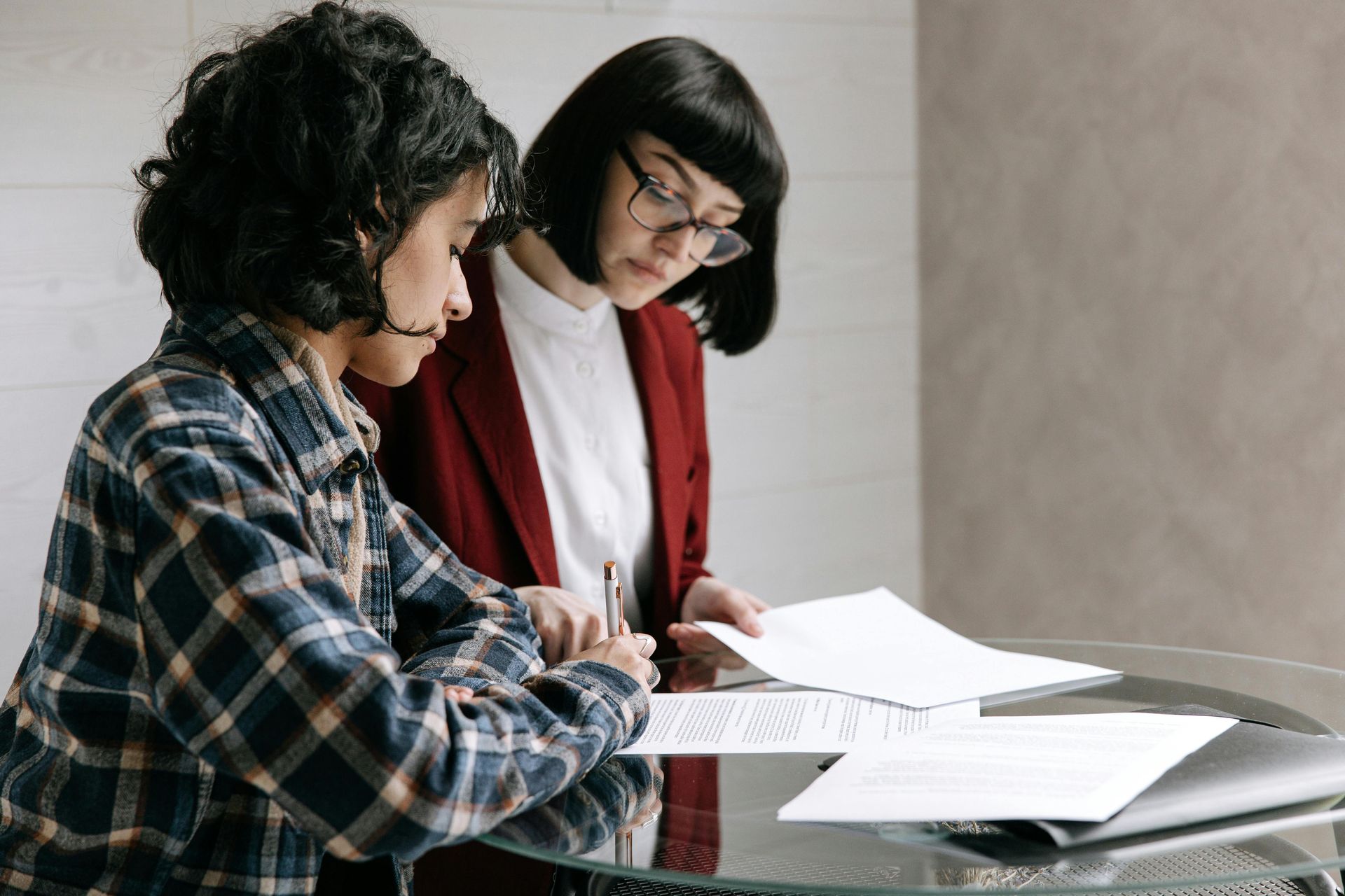 A man and a woman are looking at a laptop computer in a kitchen.