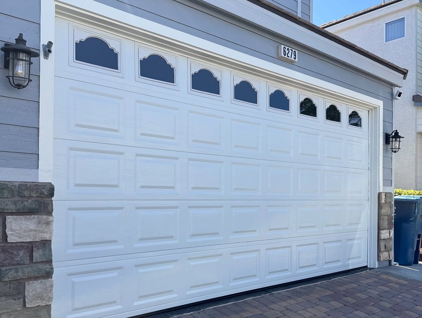 White garage door with arched windows; exterior of a house.