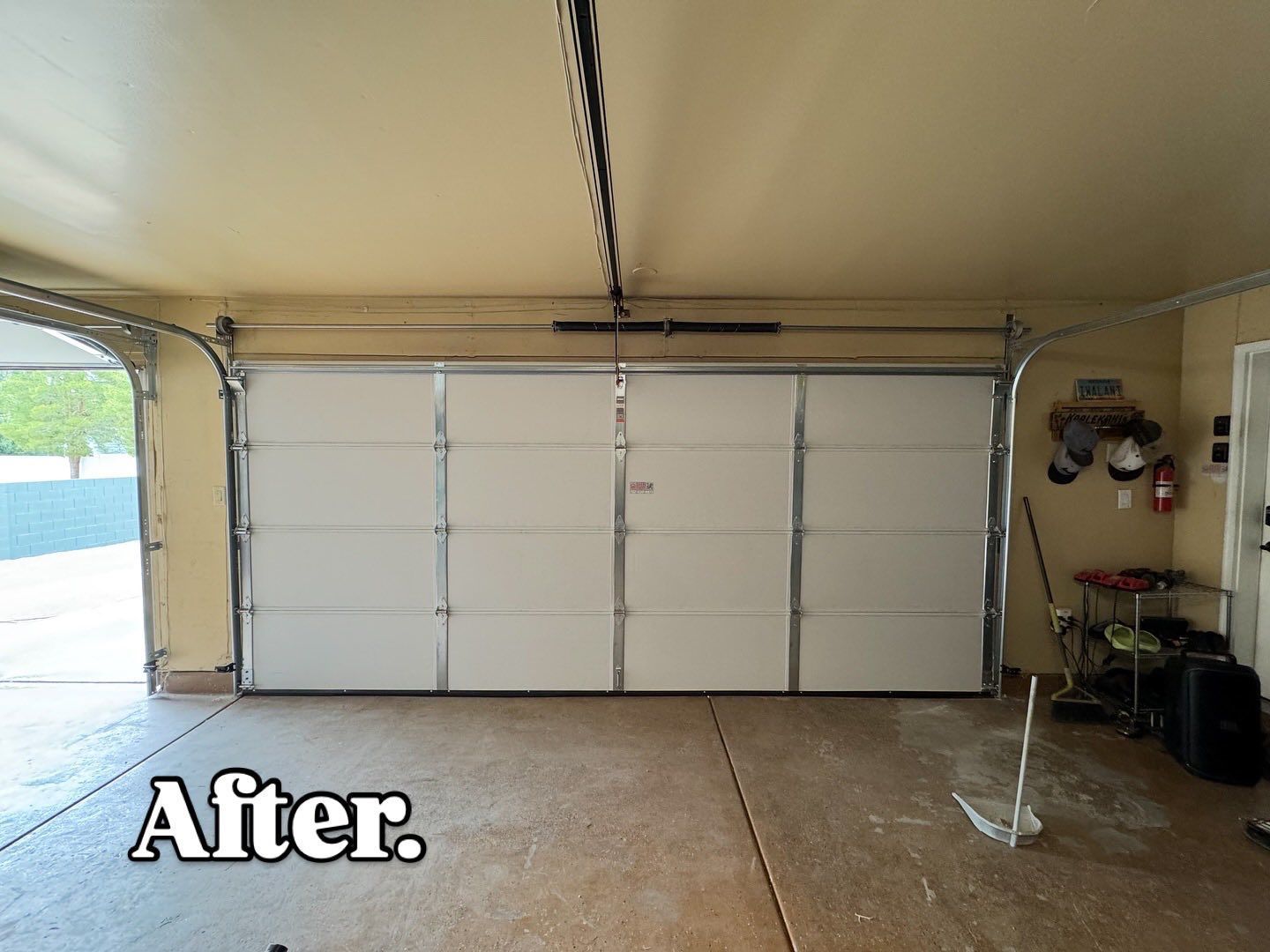 Interior view of a garage with a closed white garage door. 