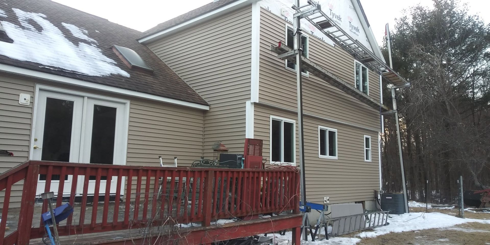 A large house with a red deck in front of it.