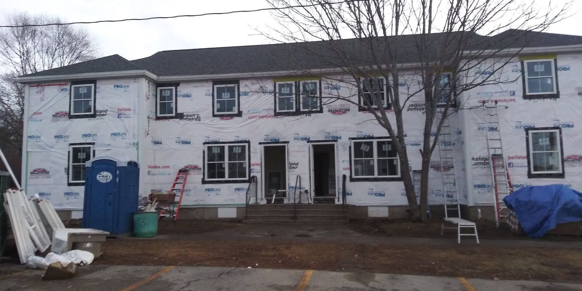 A large white house with a blue toilet in front of it