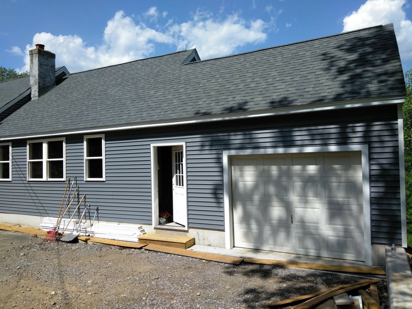 A house with a gray siding and a white garage door