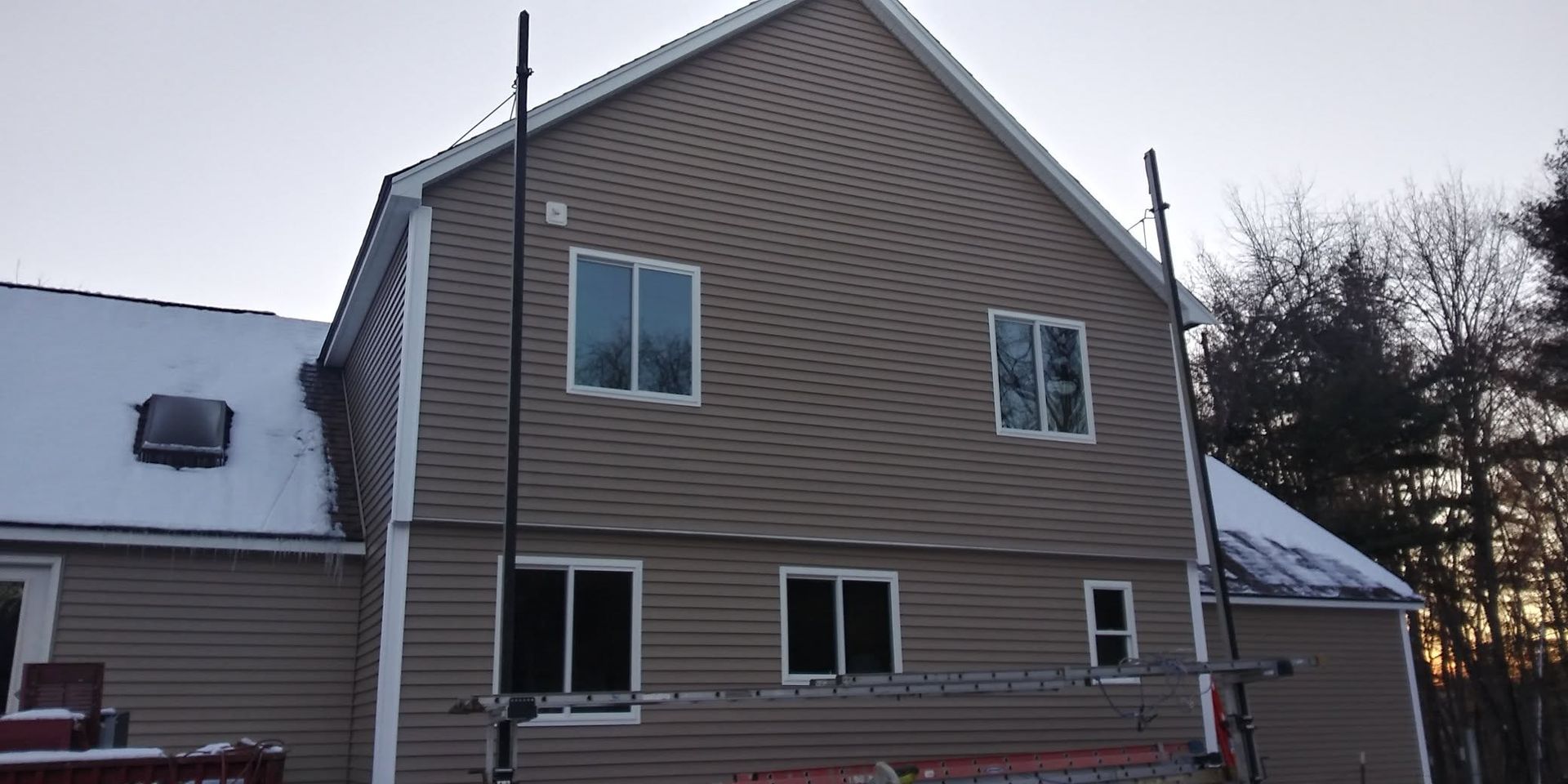 A house with a lot of windows and a roof that is covered in snow.