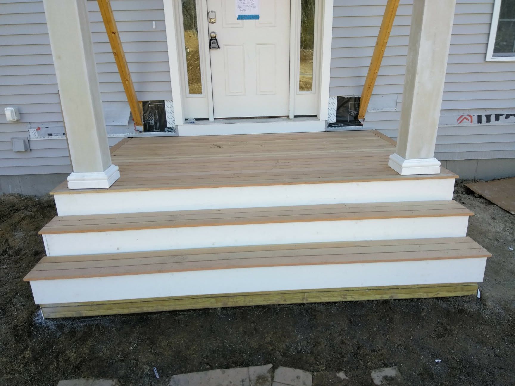 A porch with wooden steps and a white door