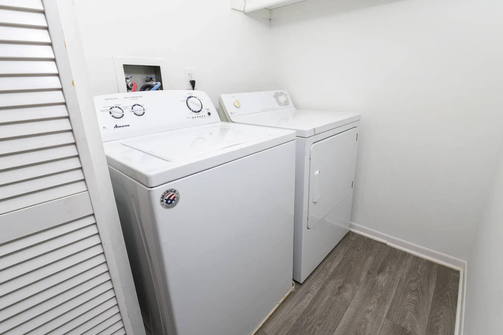 Laundry closet with a white top-load washer and white front-load dryer.
