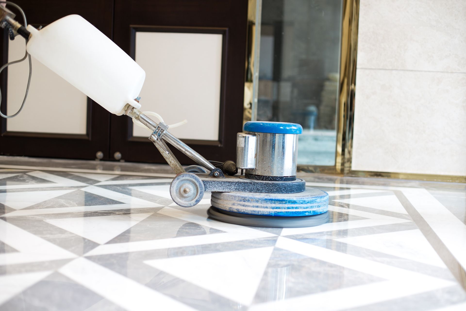Floor polishing machine cleaning a patterned marble floor.