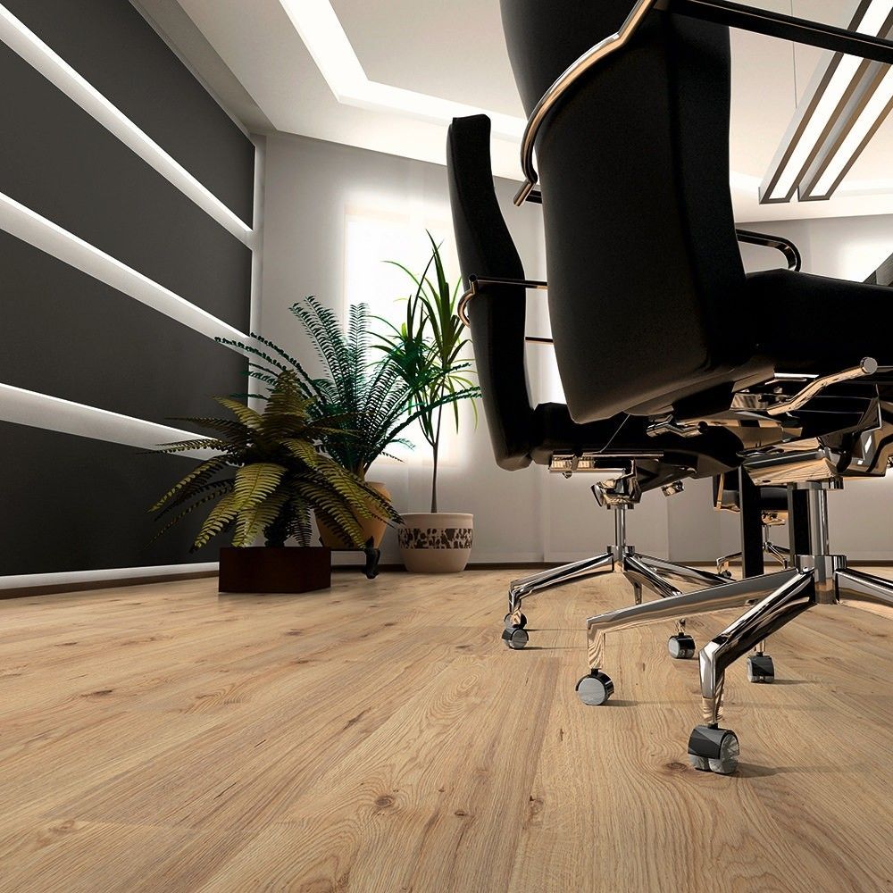 Office interior with wood flooring, black chairs, and potted plants.