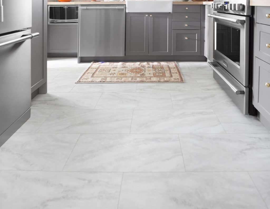 Kitchen with gray cabinets, stainless steel appliances, and marble-look tile flooring.