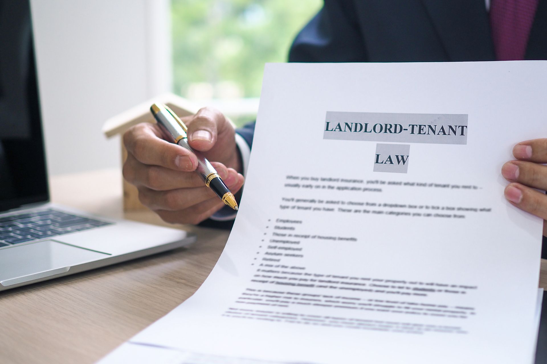 Landlord tenant lawyer reviewing house contract with pen, legal help for rental property disputes. Landlord tenant lawyer reviewing house contract with pen, legal help for rental property disputes.