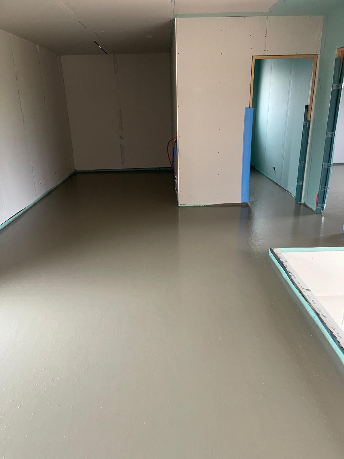 Une grande pièce vide avec un sol et des murs en béton.