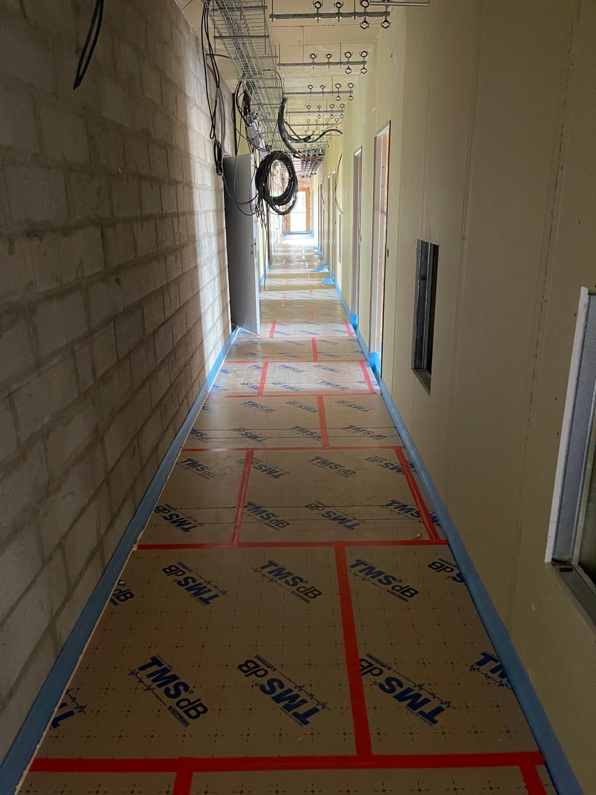 Un long couloir avec beaucoup de fils suspendus au plafond.