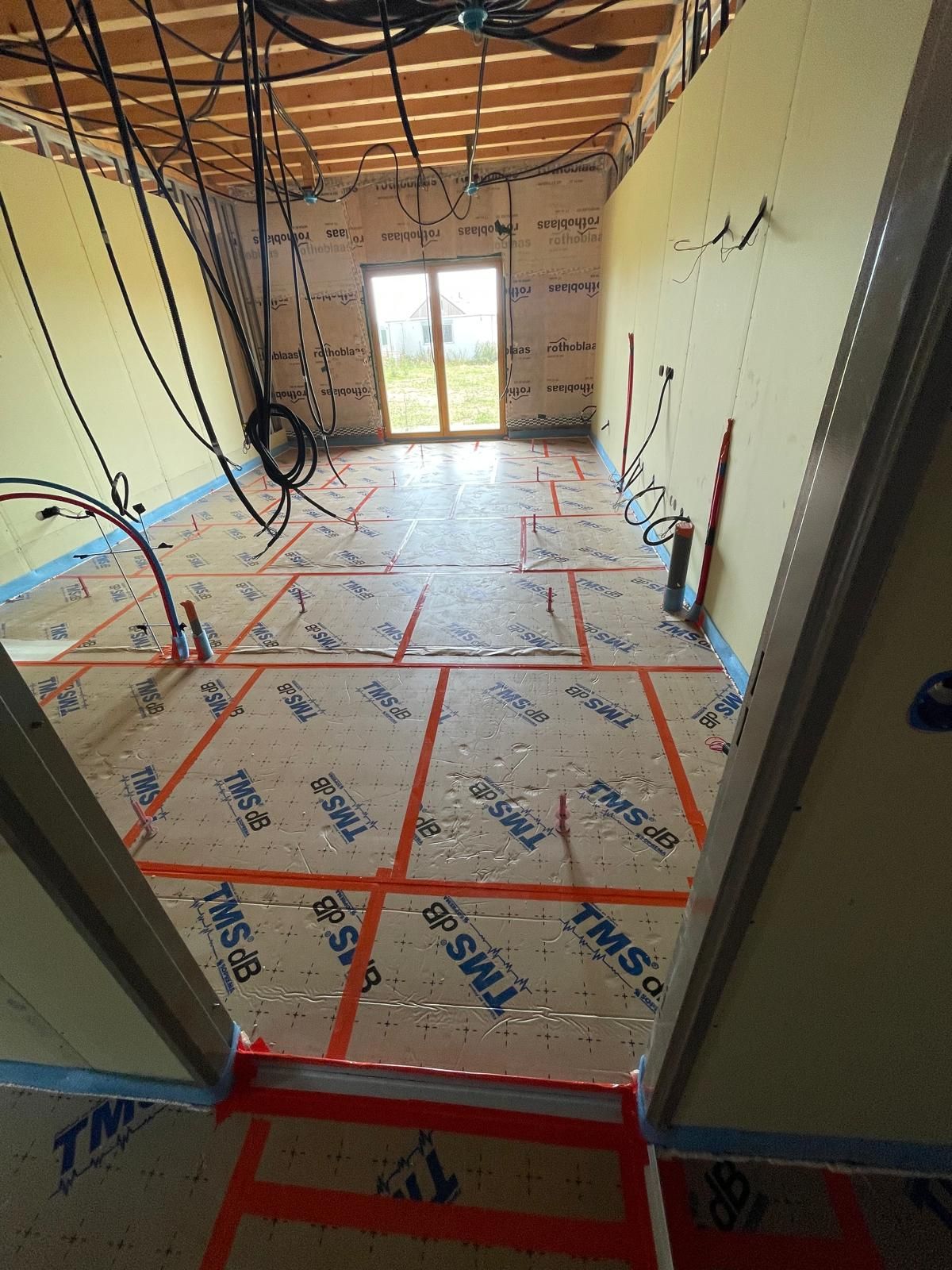 Une pièce avec beaucoup de fils suspendus au plafond.