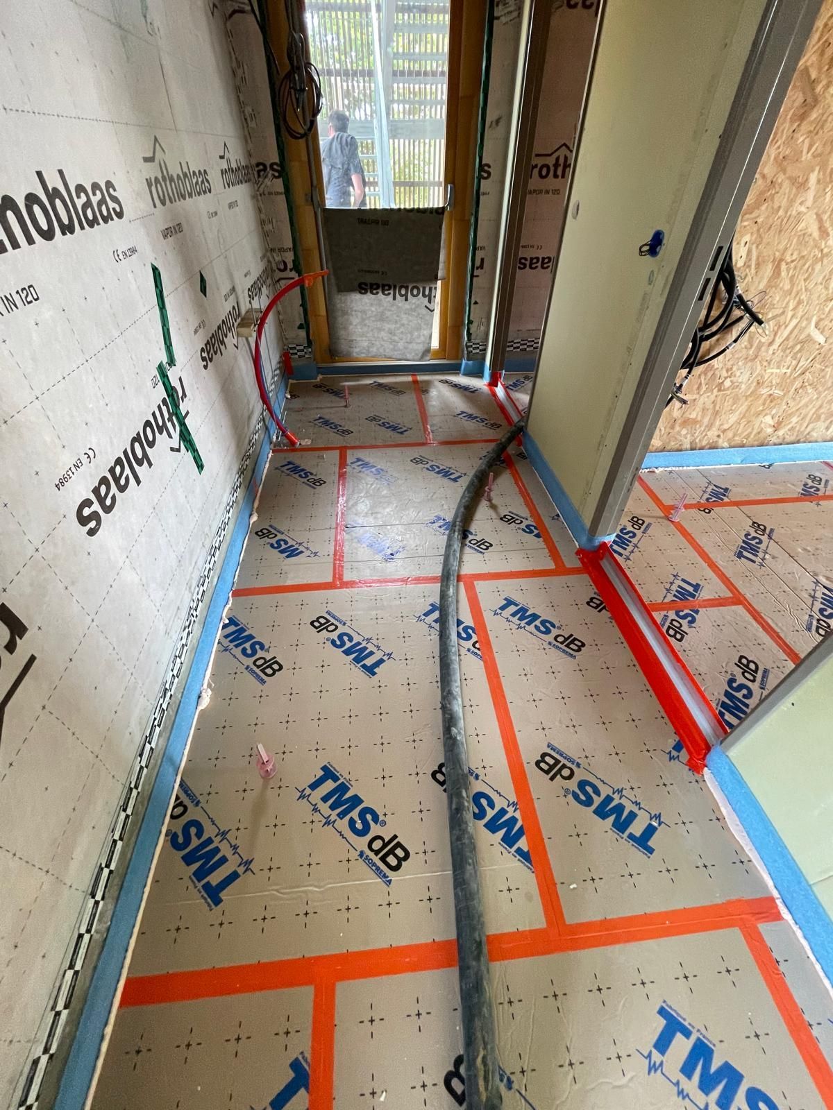 Un couloir avec du ruban adhésif TMS sur le sol et les murs