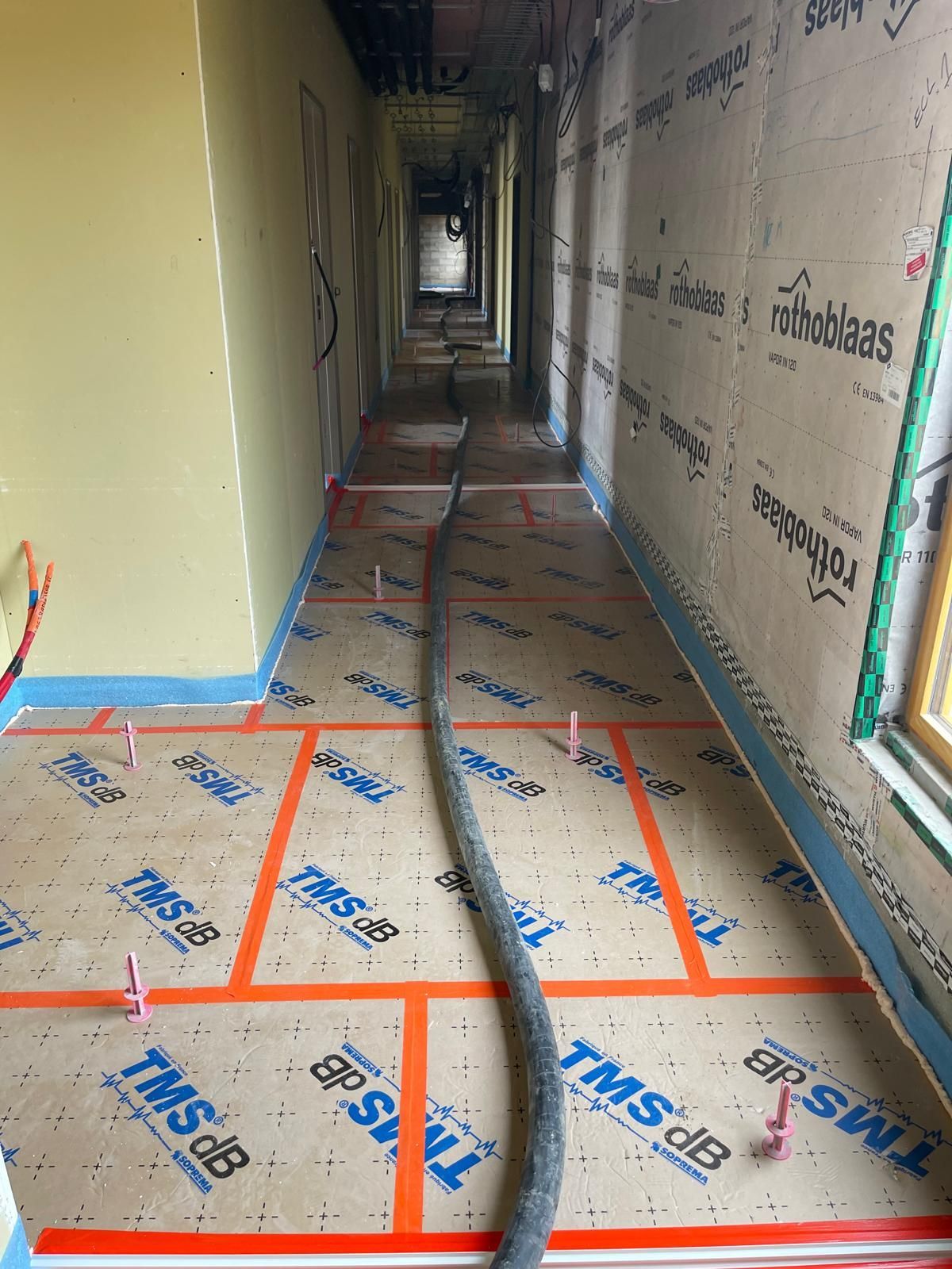 Un long couloir avec un tuyau au milieu.