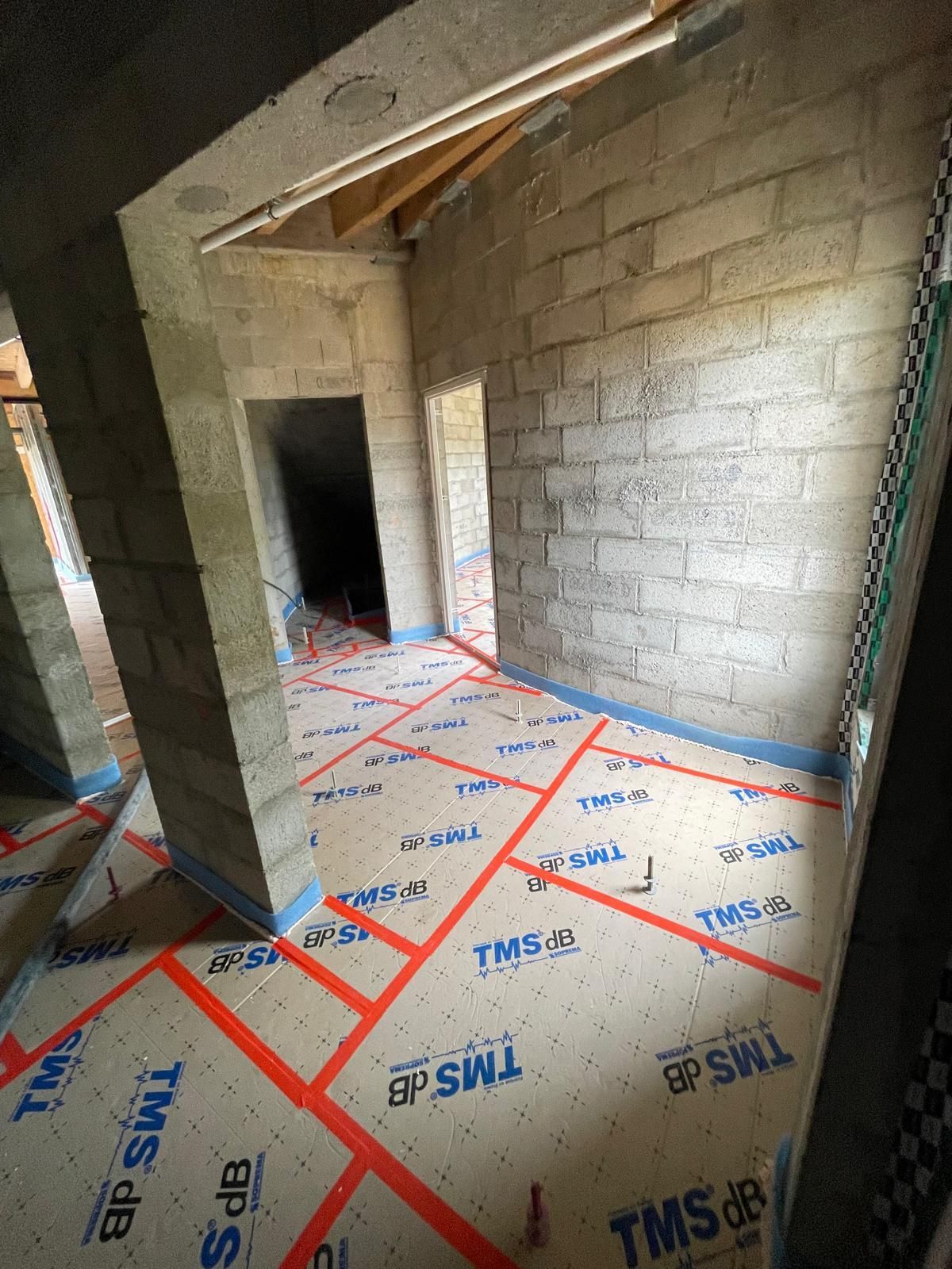 Une pièce avec un mur de briques et un ruban TMS sur le sol.