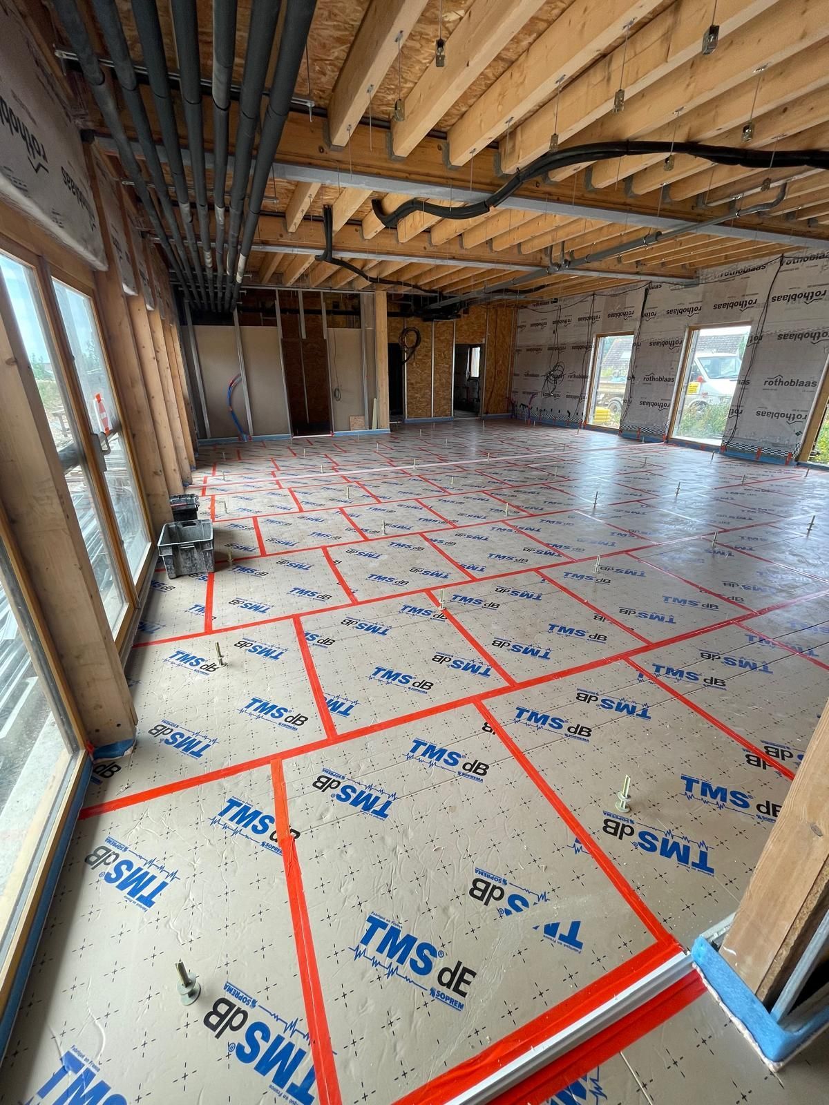 Une grande pièce avec beaucoup de fenêtres et beaucoup de ruban adhésif sur le sol.