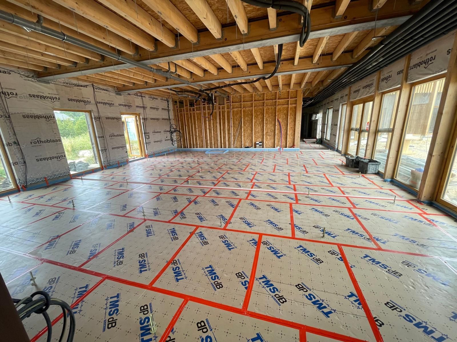 Une grande pièce avec beaucoup de fenêtres et beaucoup d'isolation au sol.